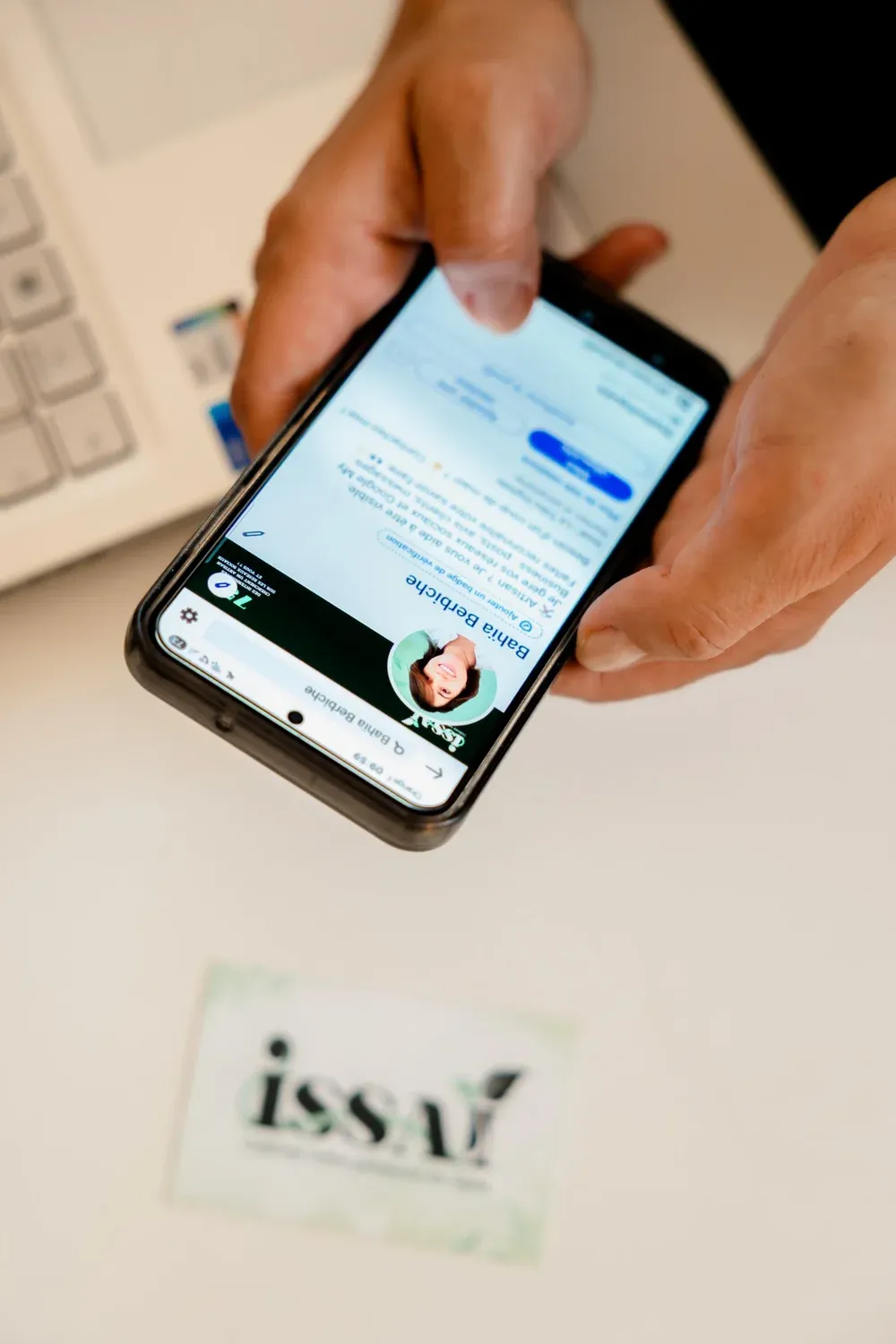 Bahia, fondatrice d’ISSAÏ, consulte le profil d’un client sur son téléphone